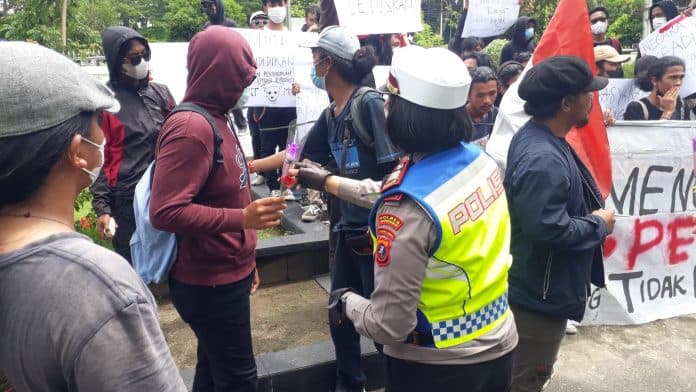 polwan_polres_siantar_berikan_bunga_kepada_pendemo